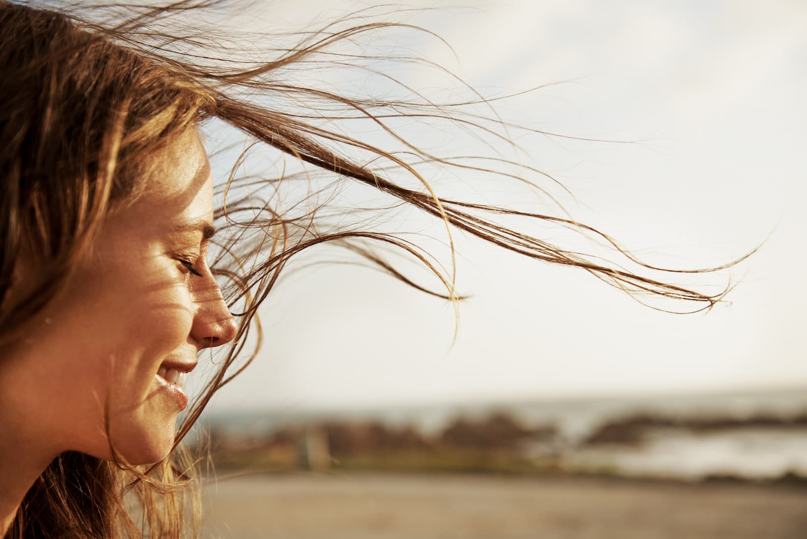 A women smiling while wind blows through her hair
